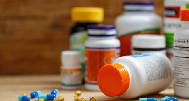 Medicine bottles and tablets on wooden desk Medicine bottles and tablets on wooden desk
